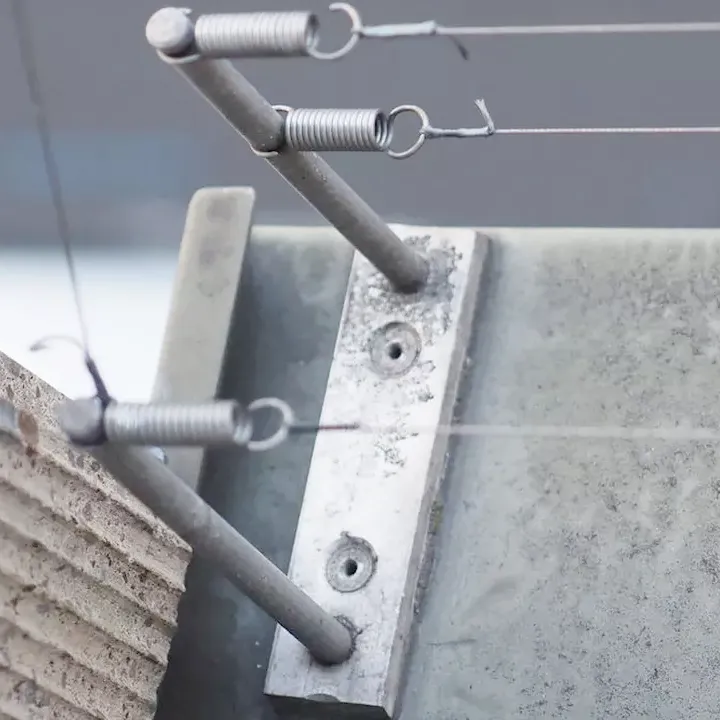 Mise en place d'un support double tige sur un acrotère pour créer une barrière à deux niveaux contre les pigeons.